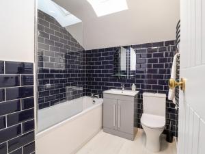 ein Badezimmer mit Toilette, Badewanne und Waschbecken in der Unterkunft Poppy Cottage in Southwold + 12 Fotos