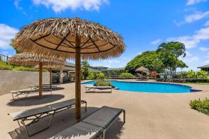 una panchina sotto un ombrellone accanto alla piscina di Kapalua Golf Villas by Coldwell Banker Island Vacations a Kahana