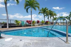 a swimming pool with palm trees in a resort at Big Island Na Hale O Keauhou by Coldwell Banker Island Vacations in Kailua-Kona