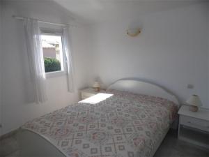 una camera bianca con un letto e una finestra di Maison Marseillan-Plage, 3 pièces, 6 personnes - FR-1-326-397 a Marseillan
