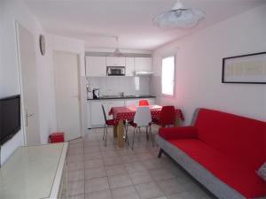 un soggiorno con divano rosso e tavolo di Maison Marseillan-Plage, 3 pièces, 6 personnes - FR-1-326-397 a Marseillan