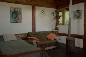 una camera con letto, divano e finestra di Cabaña Las Tejas a El Bolsón