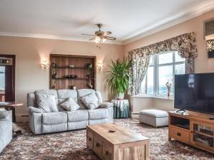 a living room with a couch and a tv at Scotch Pine in Bettws