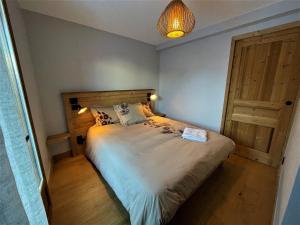 a bedroom with a large bed and a wooden door at Appartement Saint-Martin-de-Belleville, 4 pièces, 6 personnes - FR-1-452-381 in Saint-Marcel