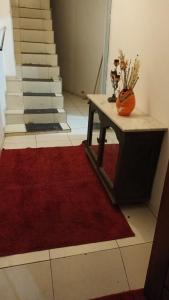 eine Treppe mit einem roten Teppich, einem Tisch und einer Treppe in der Unterkunft Hostel Palma de Leão in Salvador