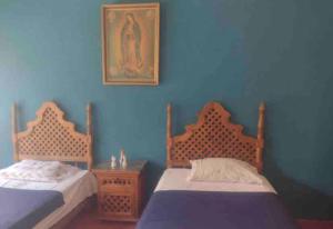 - 2 lits dans une chambre aux murs bleus dans l'établissement CASA VACACIONAL, à Cocoyoc
