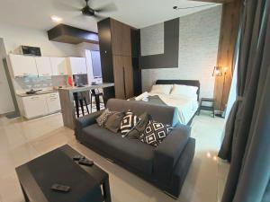 een woonkamer met een bank en een bed bij Peace home B13 in Cyberjaya
