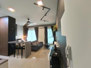 cocina y sala de estar con sofá y mesa en Peace home B13, en Cyberjaya