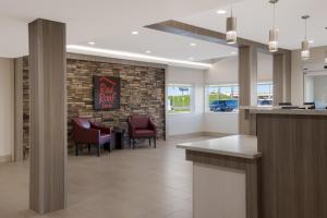 a lobby with chairs and a bar with a sign at Red Roof Inn Sulphur in Sulphur