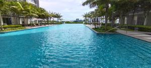 una piscina de agua azul con palmeras y edificios en Peace home B13, en Cyberjaya