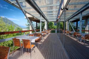 a restaurant with tables and chairs on a deck at Hotel Creina in Kranj