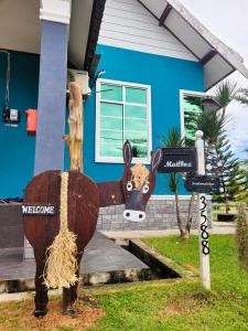 a statue of a cow in front of a house at Mawar Dayana Homestay in Jertih