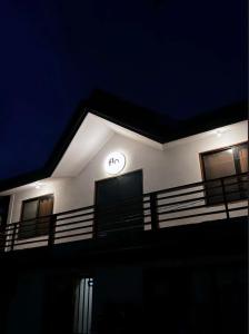 een klok aan de zijkant van een gebouw 's nachts bij Flo Island Home in General Luna