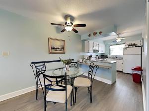a kitchen and dining room with a table and chairs at Villas on the Gulf #H6 in Pensacola Beach