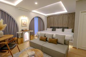 1 dormitorio con cama, sofá y mesa en R2 Hotel Chiangmai en Chiang Mai