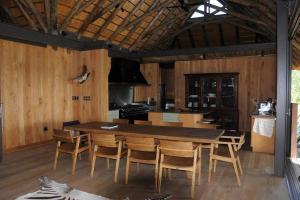 a kitchen and dining room with a table and chairs at Imvubu Lodge, Royal Jozini PGR, eSwatini in Lavumisa