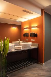 a bathroom with two sinks and orange walls at Casablanca Apart Hotel in Bishkek