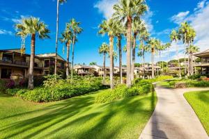 a walkway through a resort with palm trees at Wailea Elua, #0908 condo in Wailea