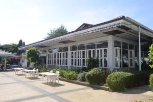a building with tables and benches in front of it at Silversand Villa Hotel in Jomtien Beach