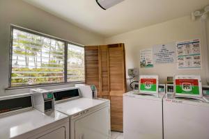 a laundry room with three machines and a window at Kauai Plantation Hale Suites by Coldwell Banker Island Vacations in Kapaa