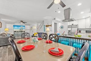 a dining room with a table and chairs and a kitchen at Seaside Serenity at Shiplap Shack, Updated Coastal Beach Home w Beach Gear and Idyllic Outdoor Living, Just Steps from the Shore in Panama City Beach