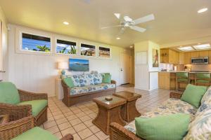 a living room with a couch and chairs and a kitchen at My Waii Beach Cottage home in Kihei