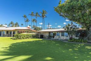 a house with a lawn in front of it at My Waii Beach Cottage home in Kihei