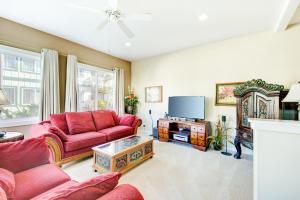 a living room with red couches and a tv at Kauai Regency at Poipu Kai by Coldwell Banker Island Rentals in Koloa