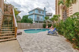 a backyard with a swimming pool and a house at Sand Castle-Pool, Game Rooms, covered outdoor space with tiki bar, 1min walk to beach in Panama City Beach