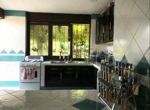 cocina con fregadero y fogones en Agradable casa rural con piscina privada, en Yautepec