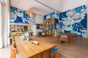 Habitación con mesa, sillas y papel pintado azul y blanco en Outrigger Surin Beach Resort - SHA Extra Plus, en Surin Beach