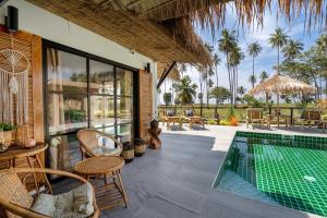 a villa with a swimming pool and a patio at Manao Seaview Pool Villa 32 - 5 Mins Walk To The Beach in Ko Lanta