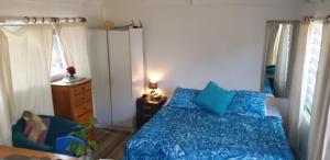 a bedroom with a bed with blue sheets and a dresser at Are Tamareni River Studio in Avarua