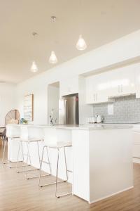 a kitchen with white cabinets and white countertops at TWO PELICANS Island Beach in Island Beach