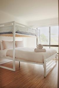 TWO PELICANS Island Beach في أيلاند بيتش: غرفة نوم بسرير أبيض مع سرير بطابقين