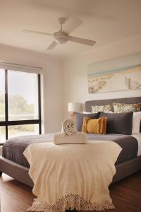 a bedroom with a large bed with a ceiling fan at TWO PELICANS Island Beach in Island Beach