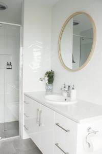 a white bathroom with a sink and a mirror at TWO PELICANS Island Beach in Island Beach