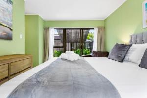 um quarto com uma cama grande e uma janela em Family Retreat close to City - WiFi Netflix Garden em Auckland