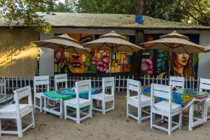 a group of tables and chairs with umbrellas at DreamCatcher Unique Retreat Yoga & Spa in Palolem