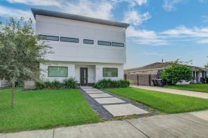 a white house with a driveway and grass at Modern 4 Bedroom 4 Full Bathroom Near Downtown in Houston