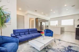 Una sala de estar con un sofá azul y una mesa. en Modern 4 Bedroom 4 Full Bathroom Near Downtown, en Houston