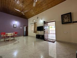 uma sala de estar com uma mesa e uma porta para um pátio em Rustic Village Farmhouse em Bangalore