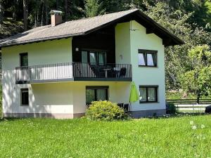 a house with a balcony and a grass field at Haus Berta in Elbigenalp
