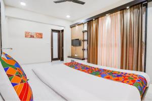 1 dormitorio con cama y ventana en FabHotel Rudra Residency en Chinchiwad