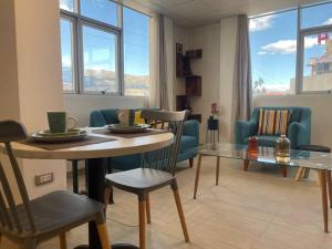 - un salon avec une table, des chaises et un canapé dans l'établissement Huancayo Suite, à Huancayo