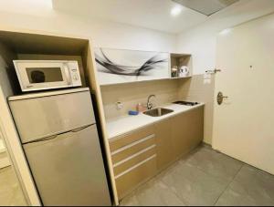 eine kleine Küche mit einer Spüle und einer Mikrowelle in der Unterkunft BRiGHT AND COZY STUDIO SUiTE EiLAT in Eilat