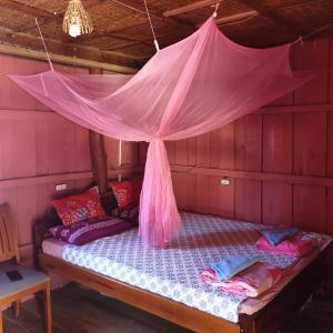 Cama en habitación con mosquitera rosa en Seng Long Guesthouse en Kaôh Rŭng (5)