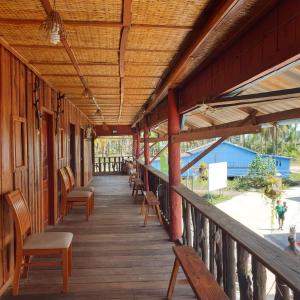 un porche de un edificio con sillas y mesas en Seng Long Guesthouse, en Kaôh Rŭng (5)