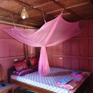 uma cama num quarto com uma rede mosquiteira rosa em Seng Long Guesthouse em Kaôh Rŭng (5)