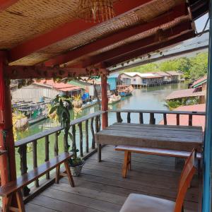 une terrasse couverte en bois avec un banc et une vue sur la rivière dans l'établissement Seng Long Guesthouse, à Kaôh Rŭng (5)